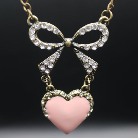 Adorn your neckline with the sweet charm of our pink heart necklace. This delicate piece features a beautifully crafted, rosy-hued heart pendant suspended from a fine chain,